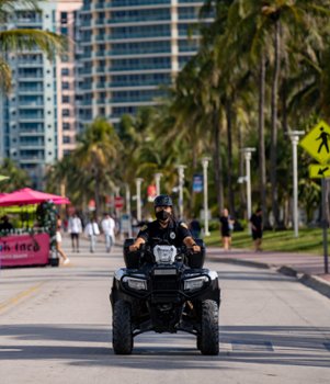 Police officer patrolling an urban boardwalk on an ATV